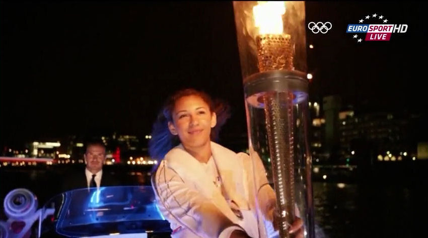 2012 Olympics opening ceremony David Beckhman in speedboat racing relay torch to stadium on thames river